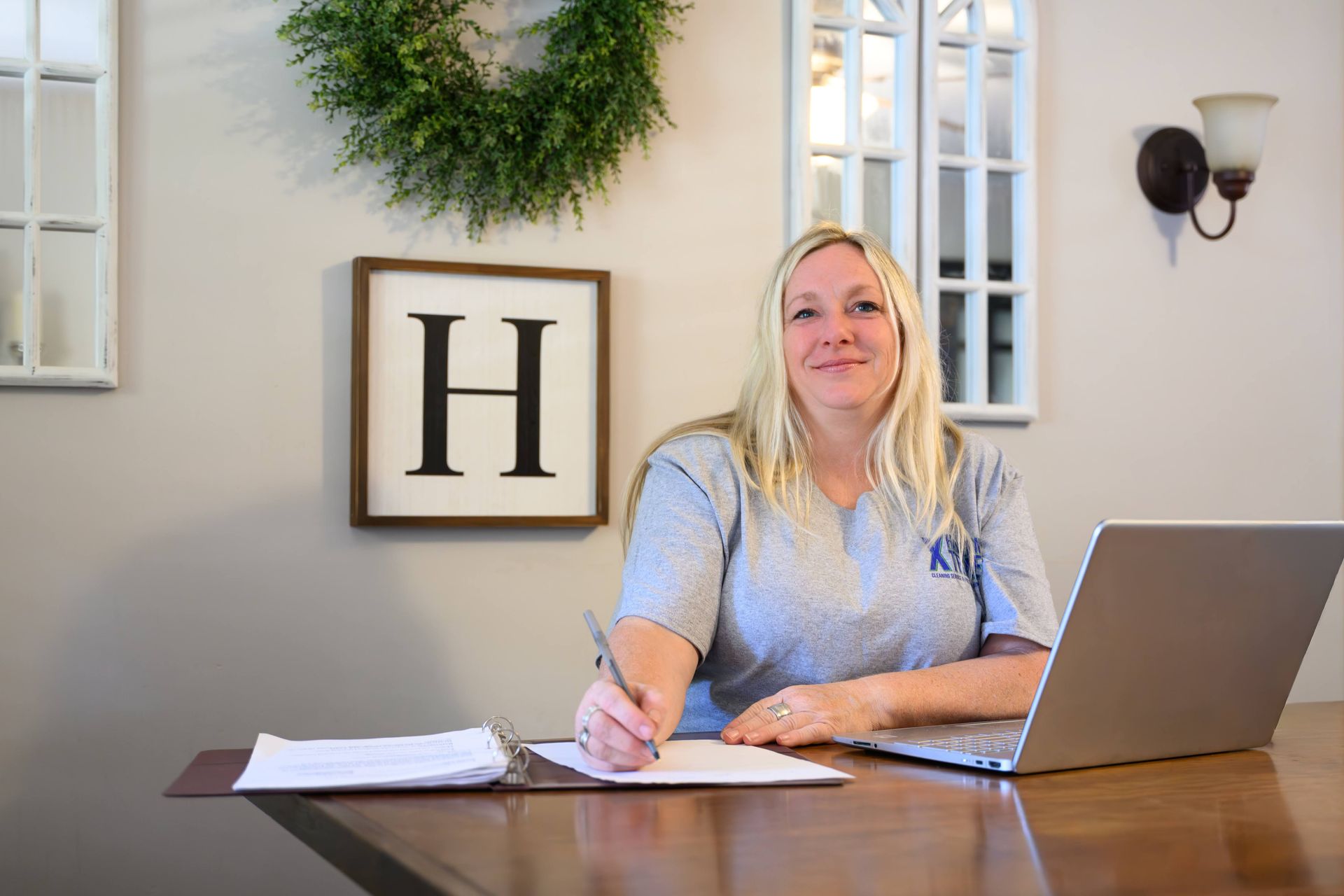 Blonde woman blowing a large blue bubblegum bubble, pink background.