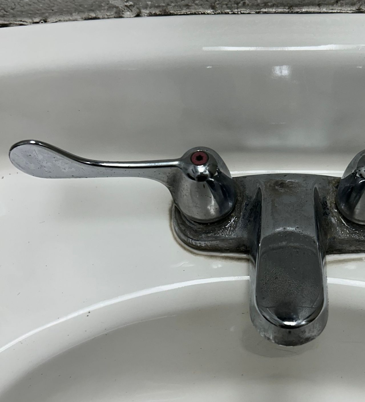 Chrome lever faucet on a white sink. The lever is in the open position.