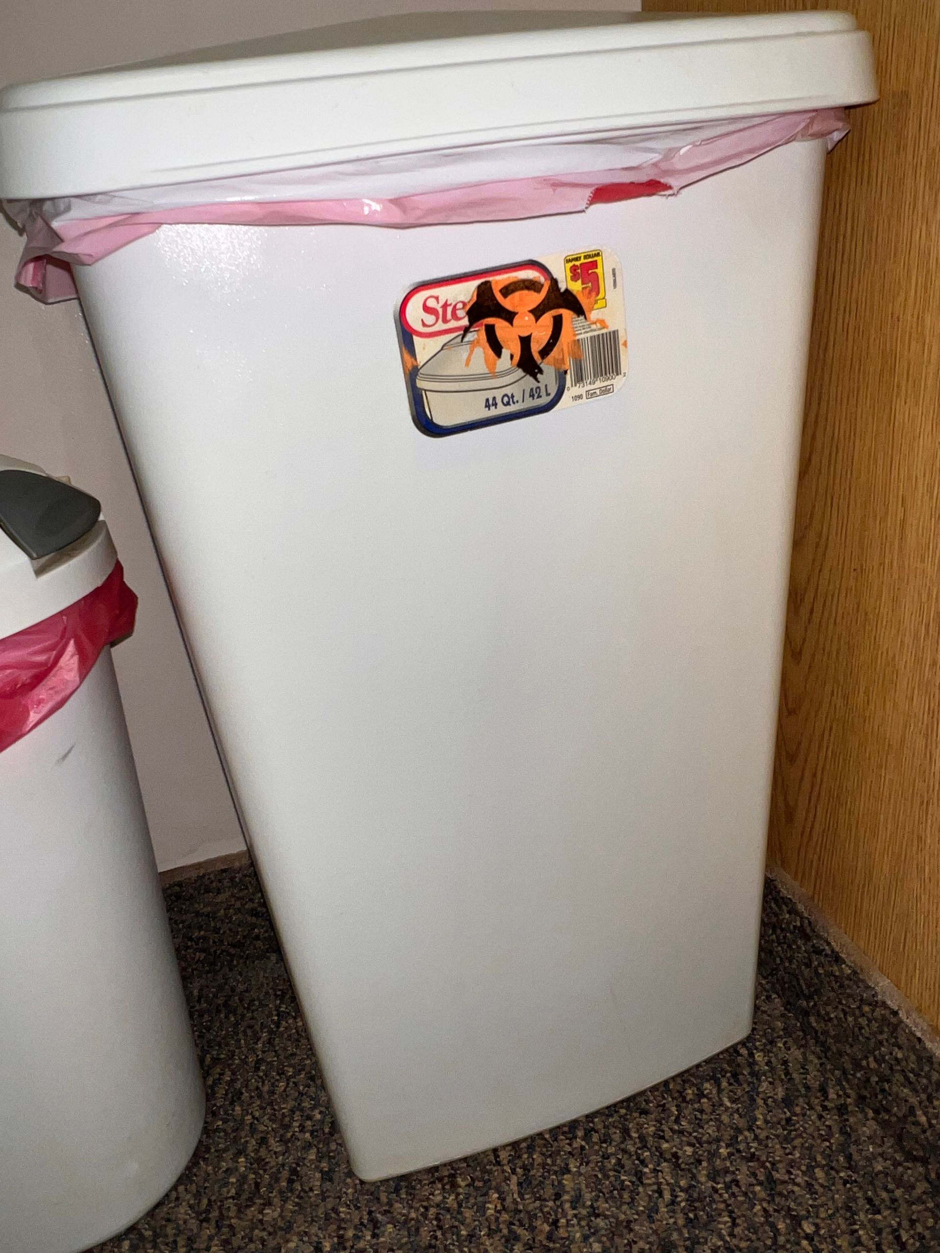 White biohazard waste bin with a red liner and a biohazard sticker.
