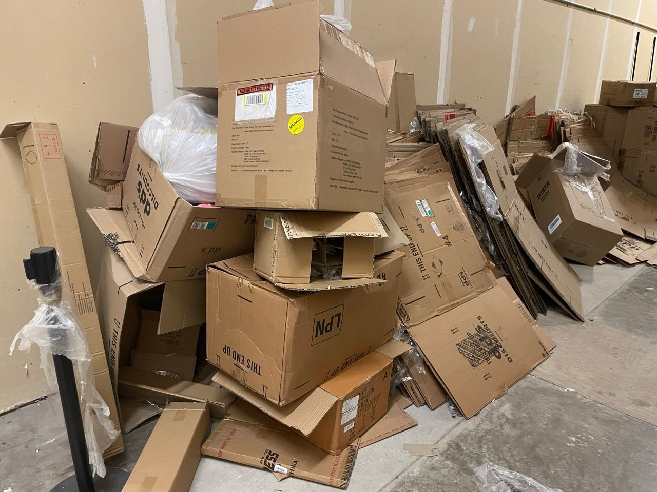 a pile of cardboard boxes and plastic bags in a parking lot .