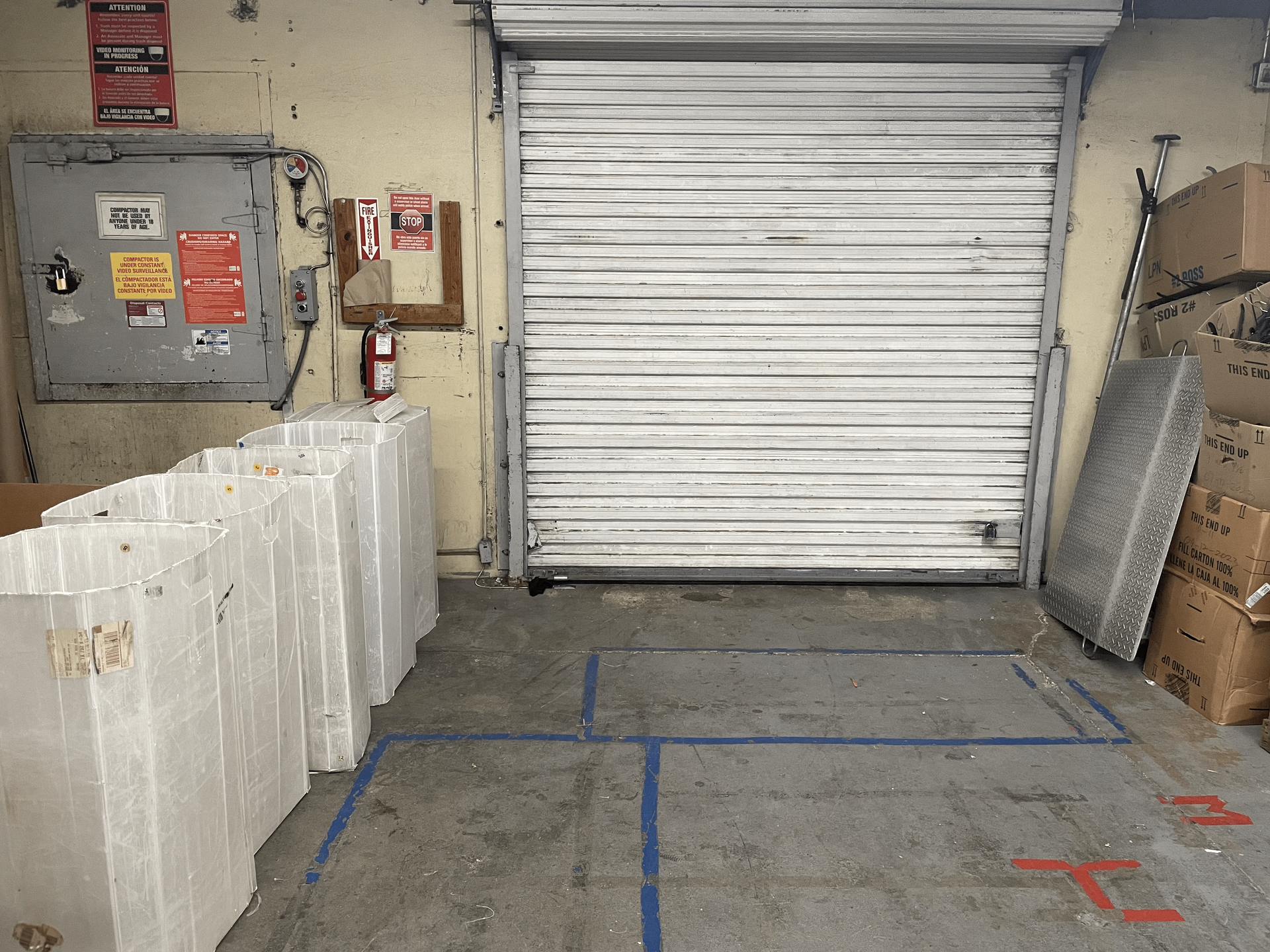a warehouse with a rolling door and boxes on the floor left clean.