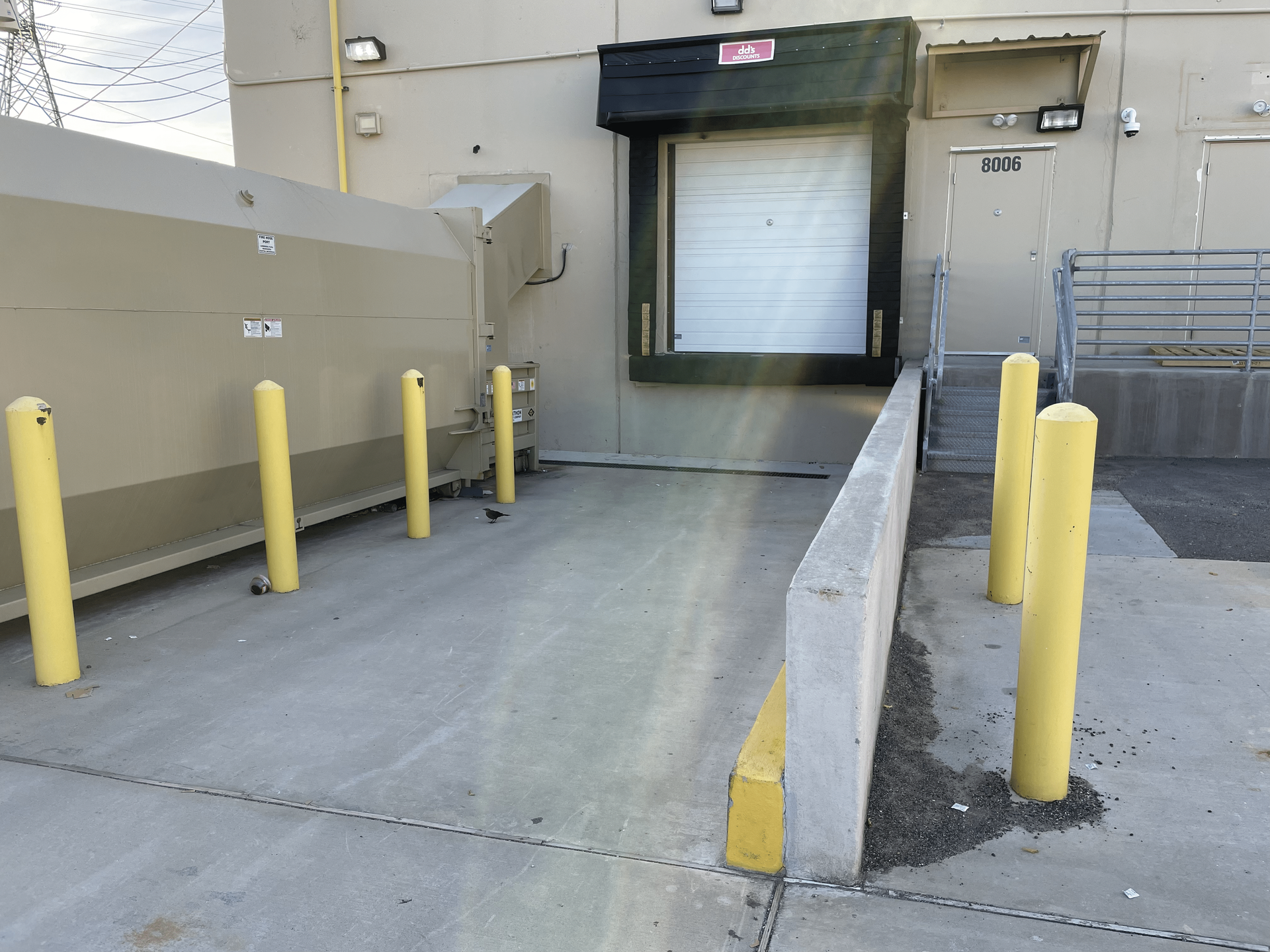 a loading dock with a ramp and yellow poles left clean