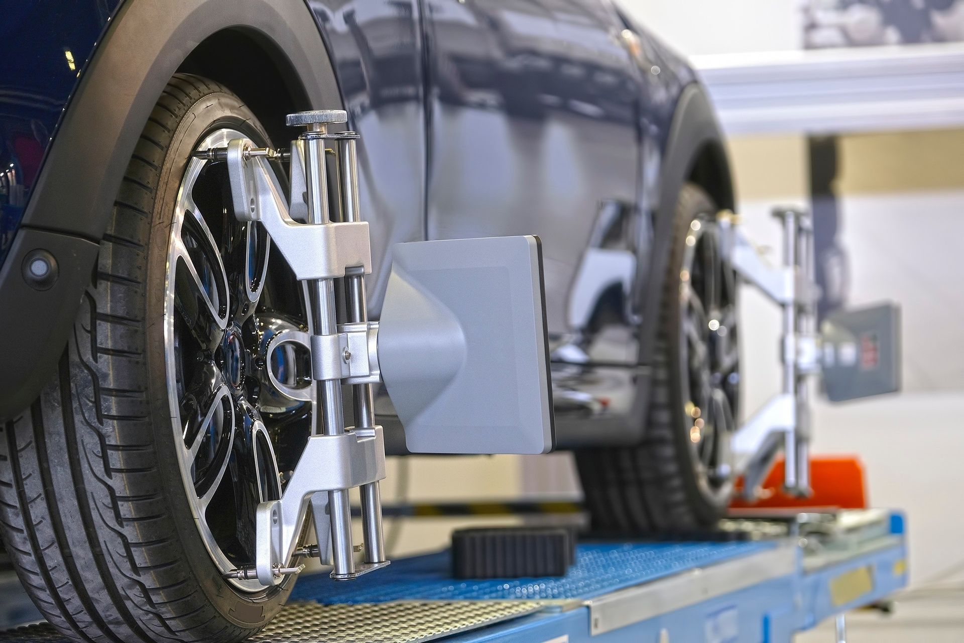 A car is being aligned with a machine in a garage.