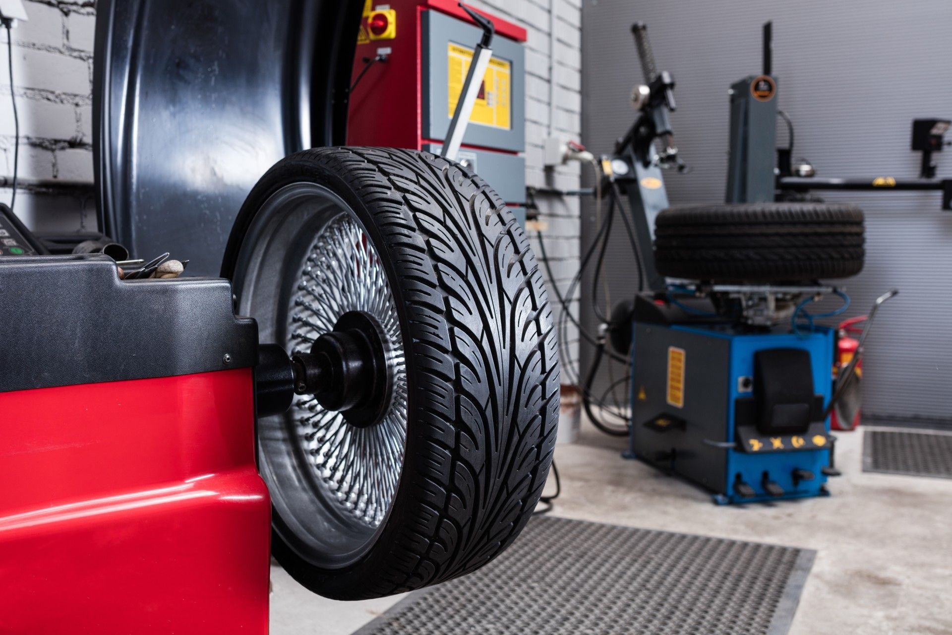 A tire is being balanced on a machine in a garage.