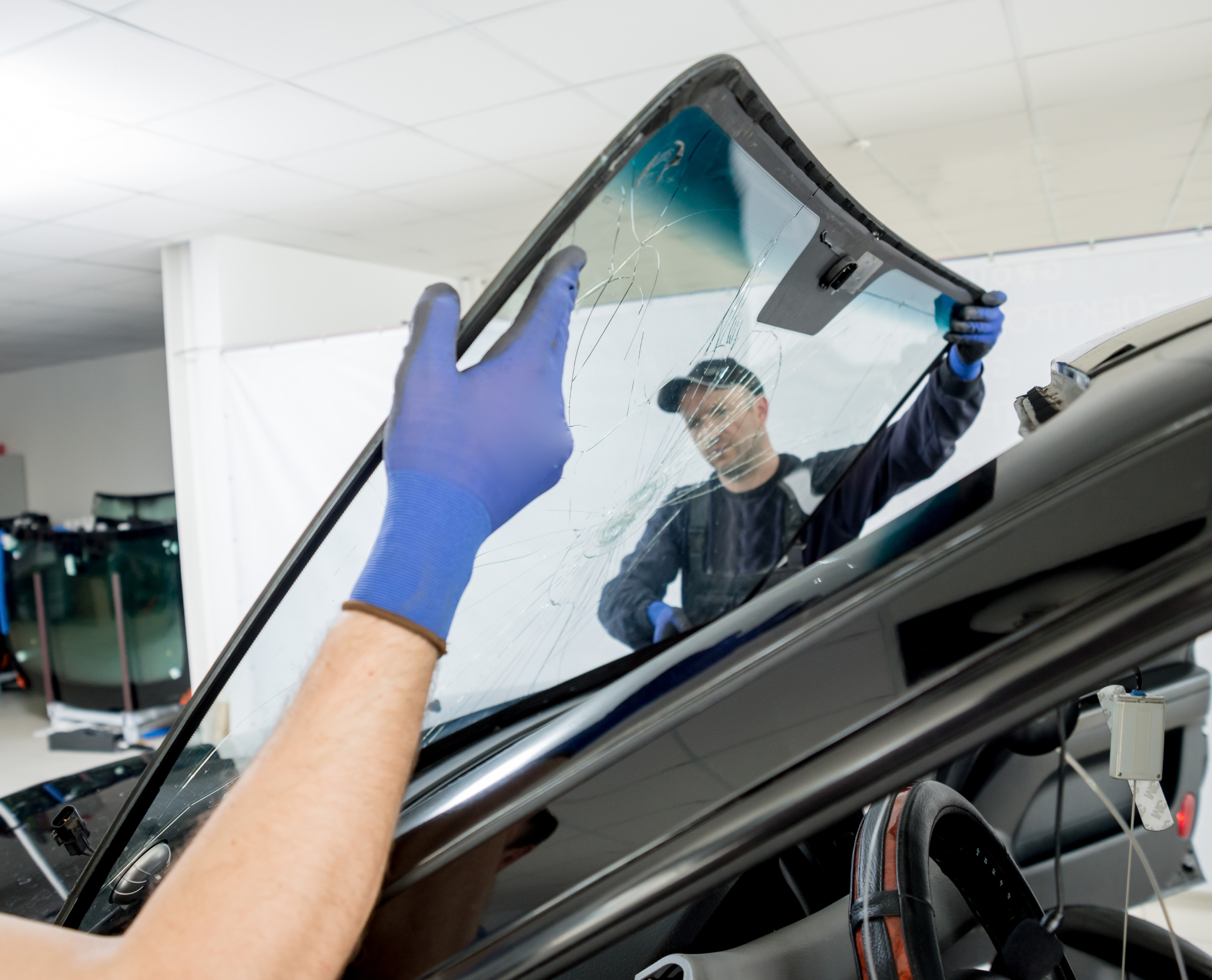 A person is installing a windshield on a car.