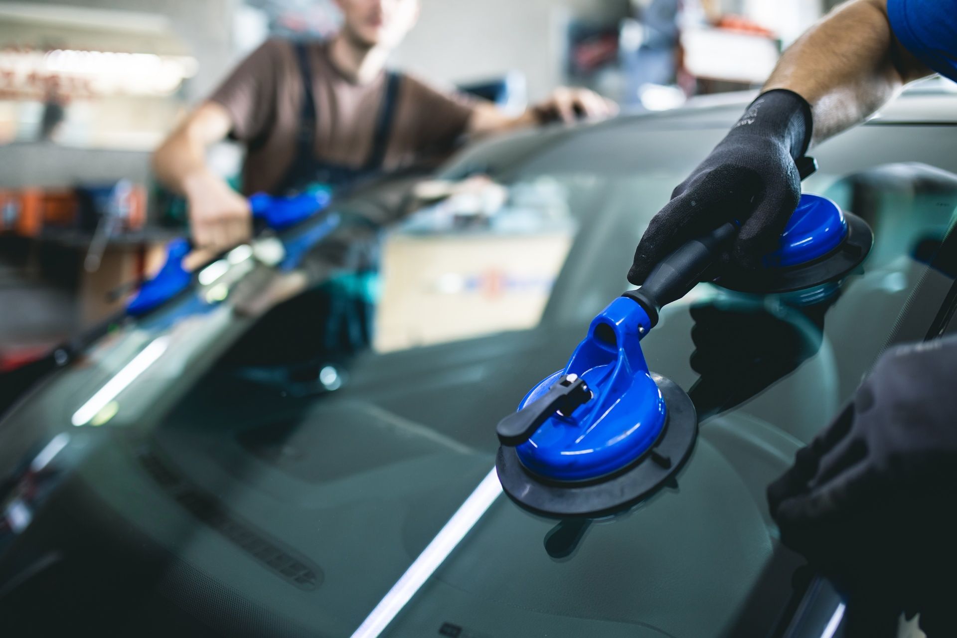 A man is installing a windshield on a car.