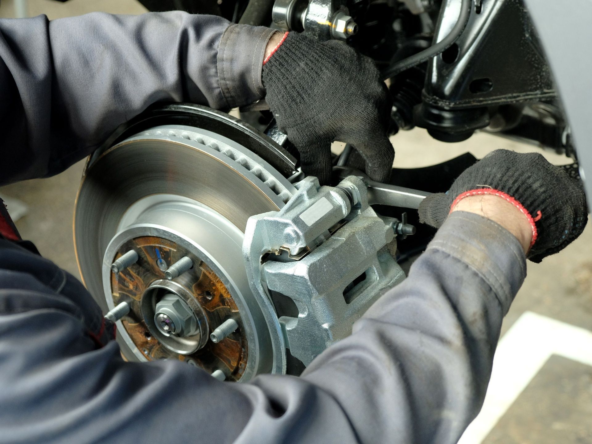 A man is working on a brake disc on a car.