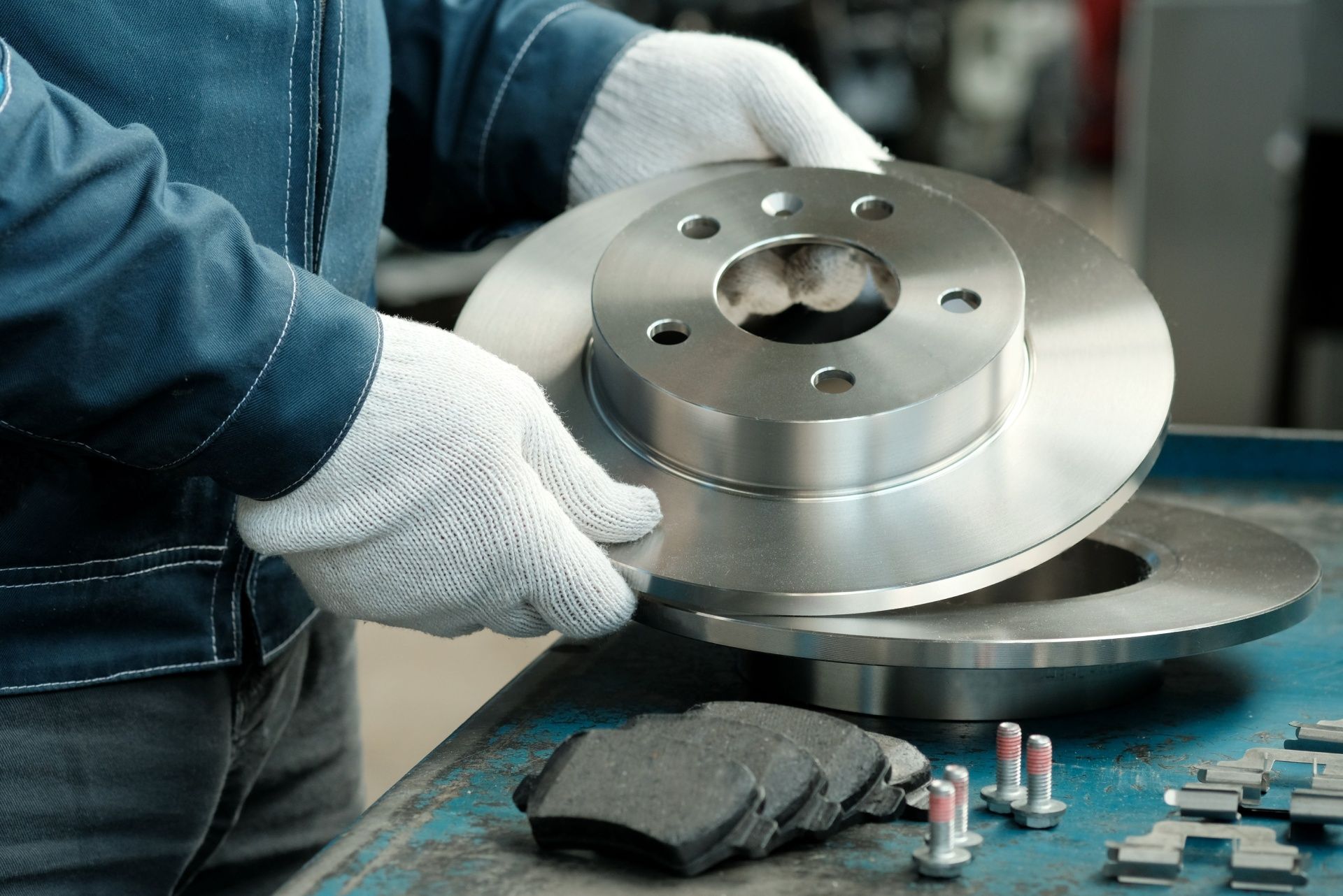 A man is holding a brake disc in his hands.