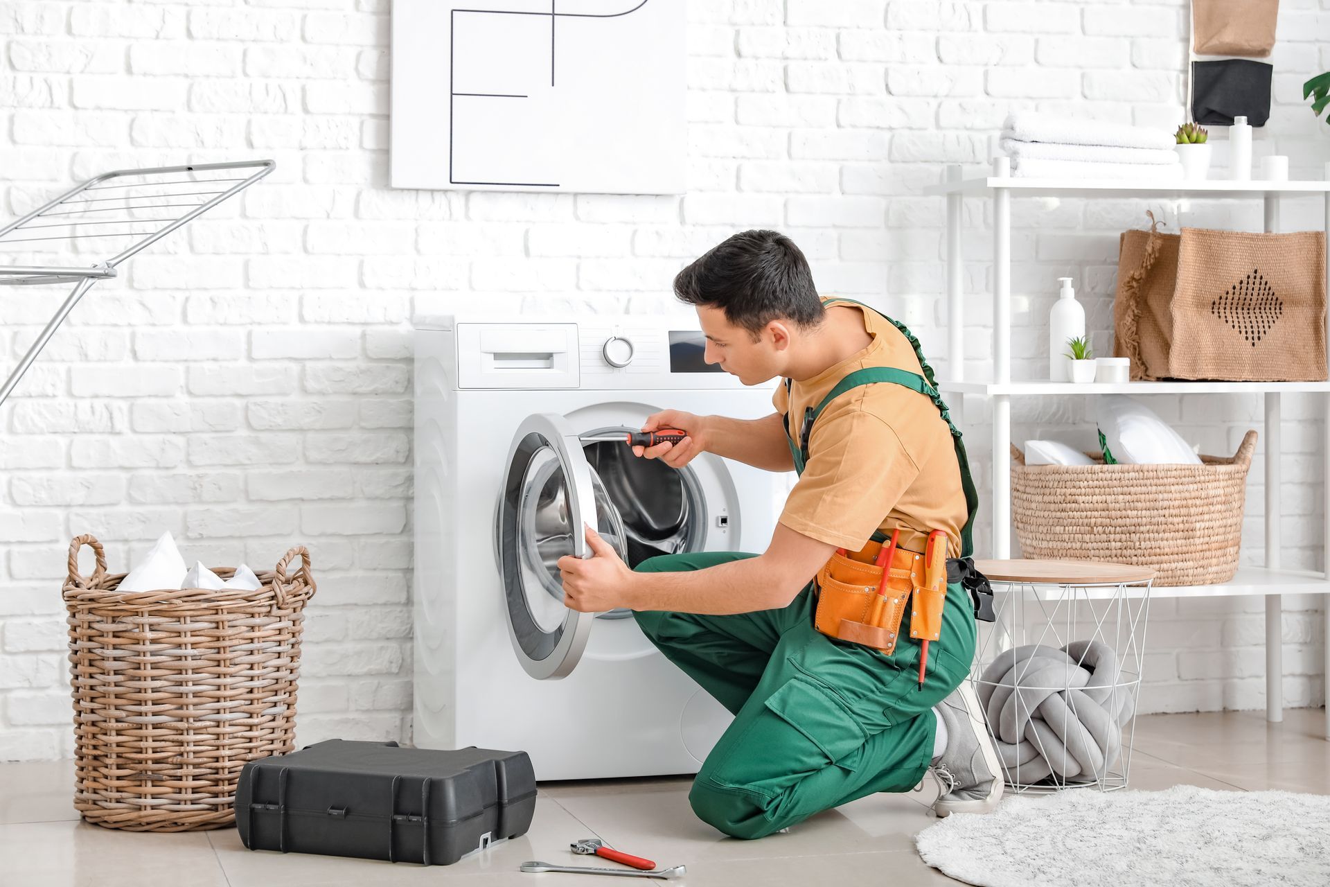 A Man Is Fixing a Washing Machine — Fast Tech Appliance Repairs in Newcastle, NSW