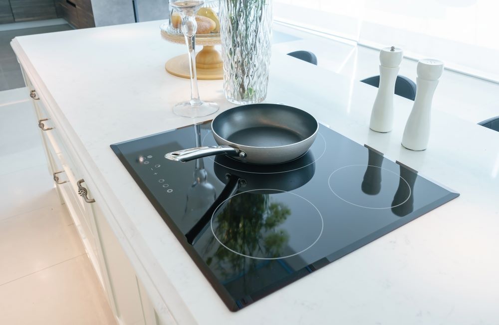 A Frying Pan Is Cooking on An Induction Stove — Fast Tech Appliance Repairs in Lake Macquarie, NSW