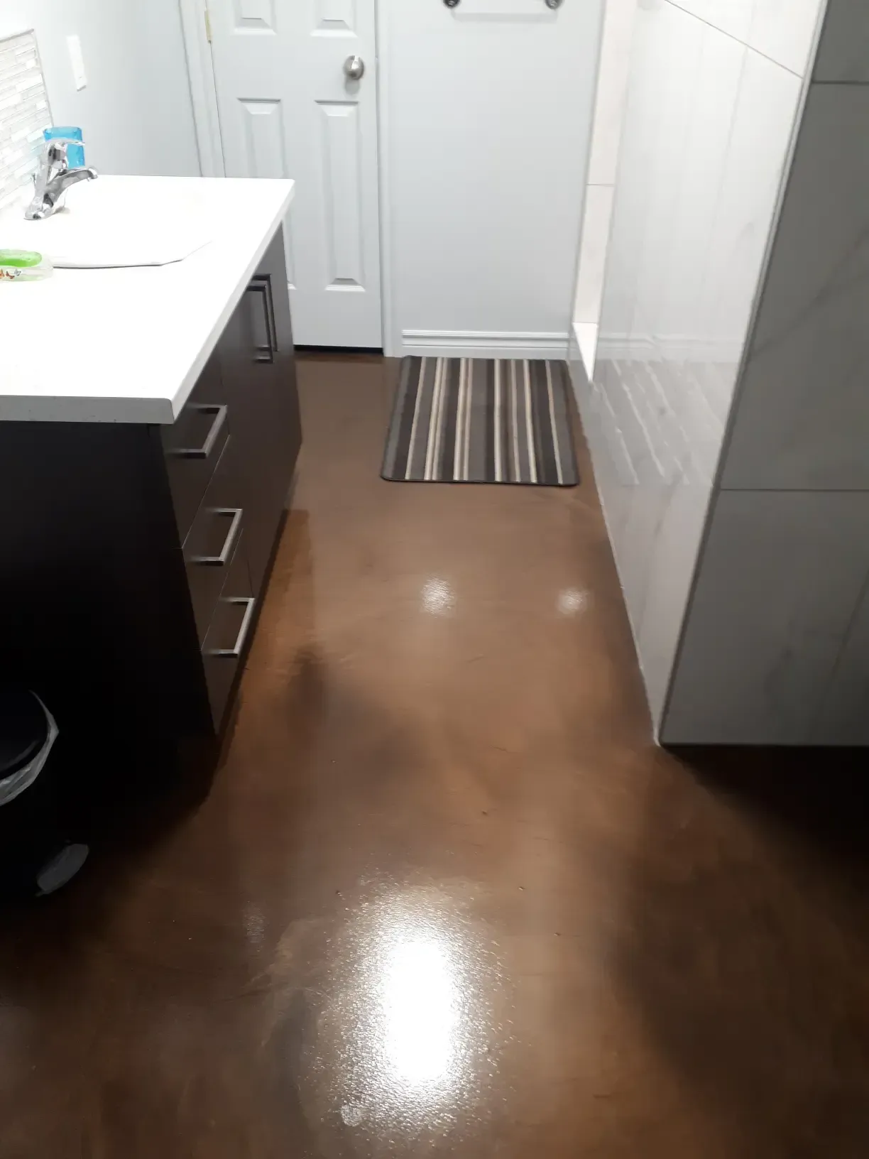 A bathroom with a sink and a rug on the floor.