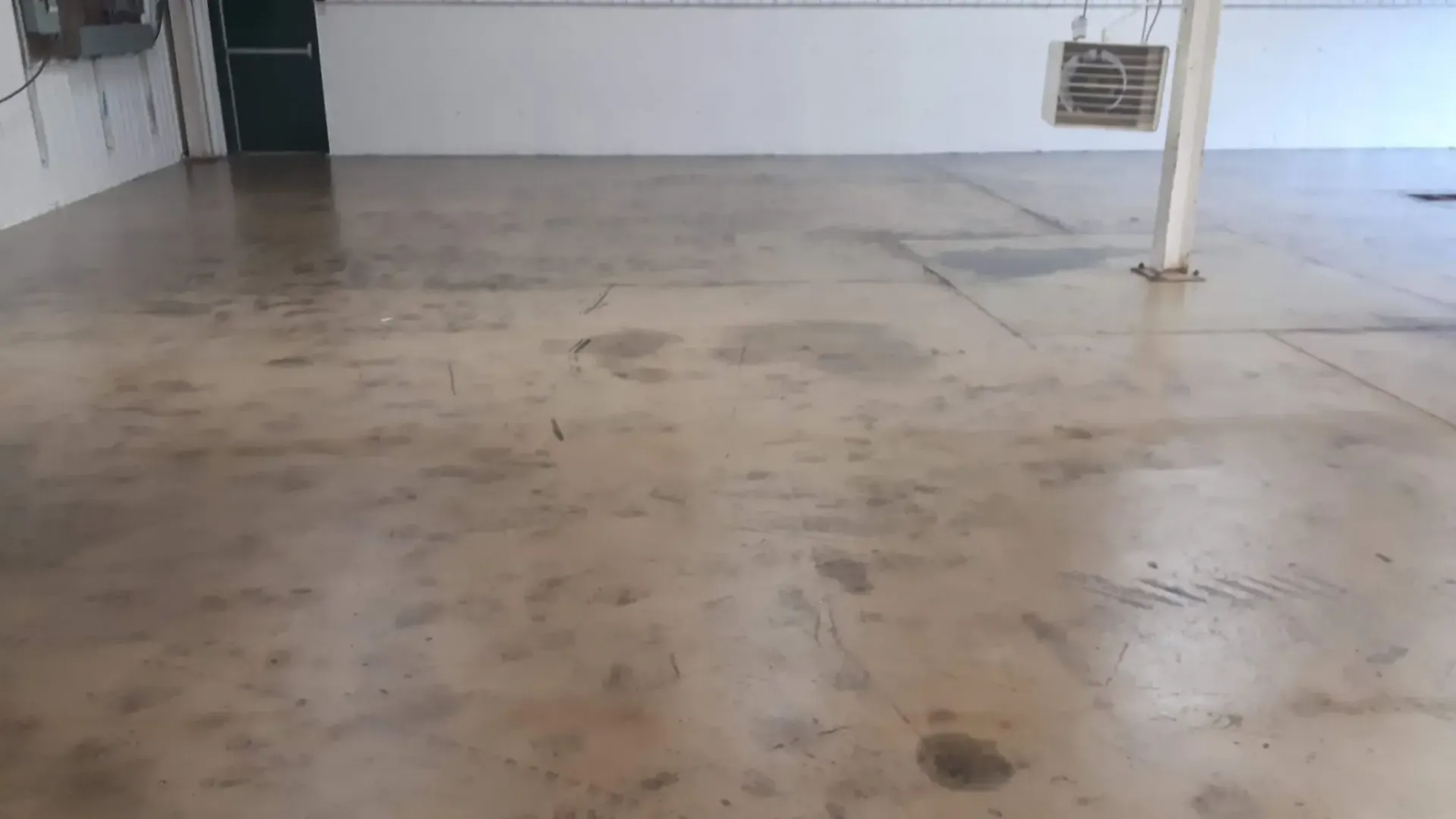 Empty room with a concrete floor, white walls, and a support column.