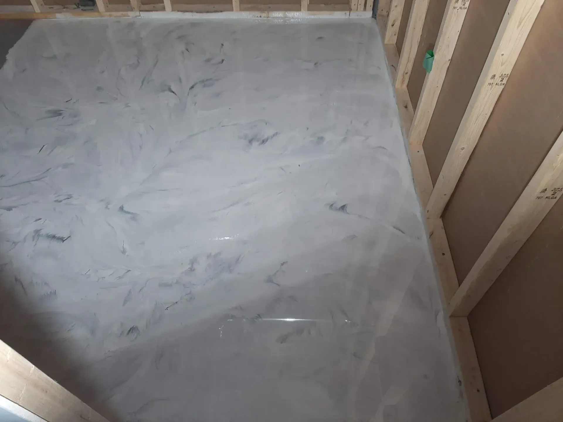 A white tile floor in a room with wooden walls.