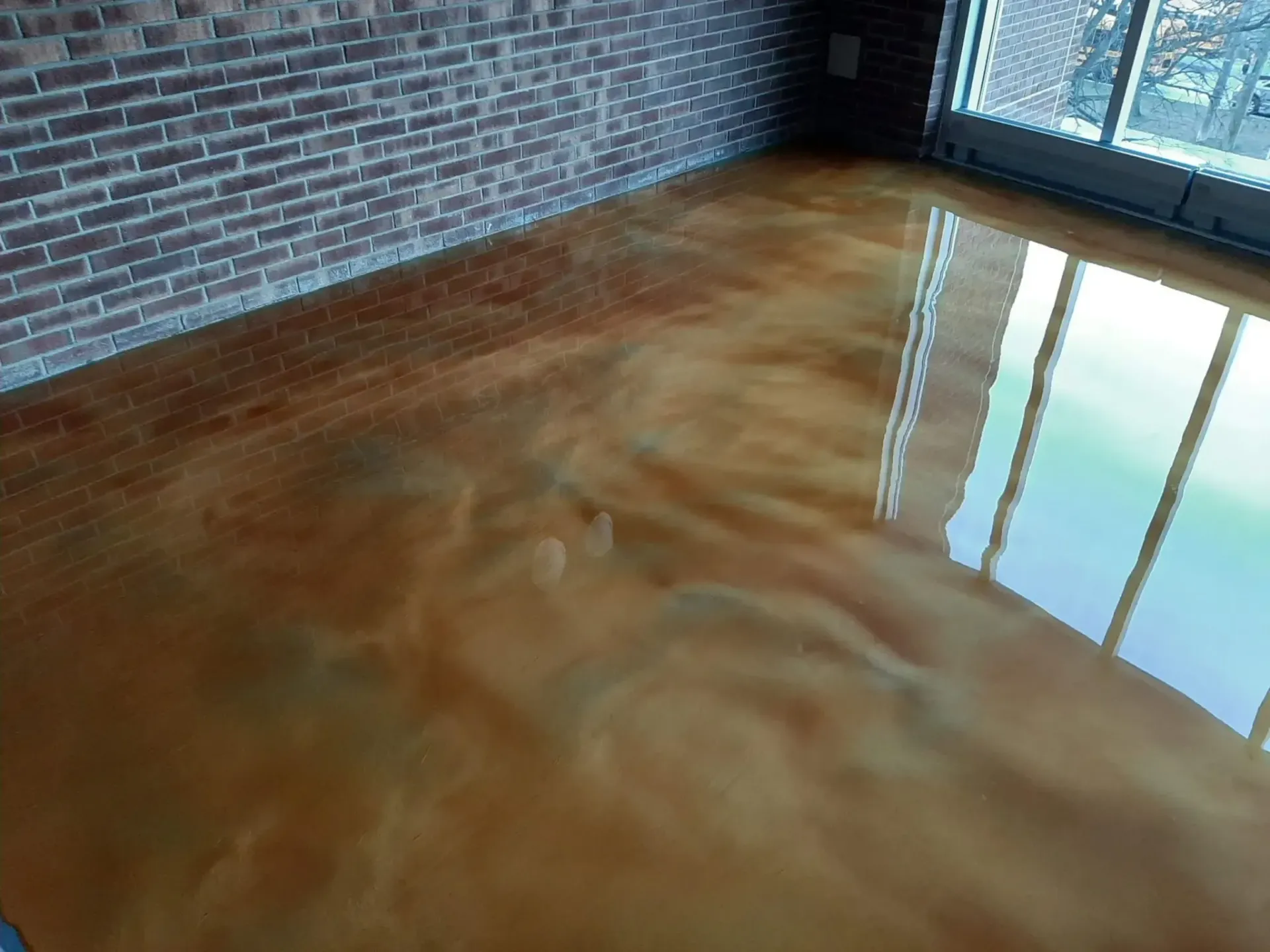 A room with a metallic floor and a brick wall.