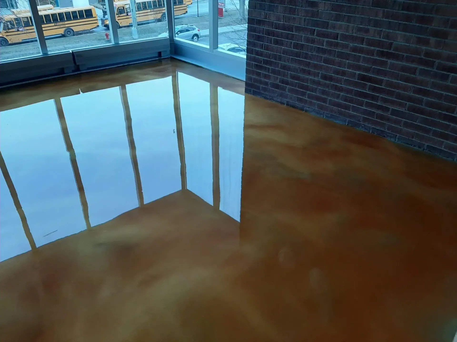 A room with a shiny floor and a brick wall.