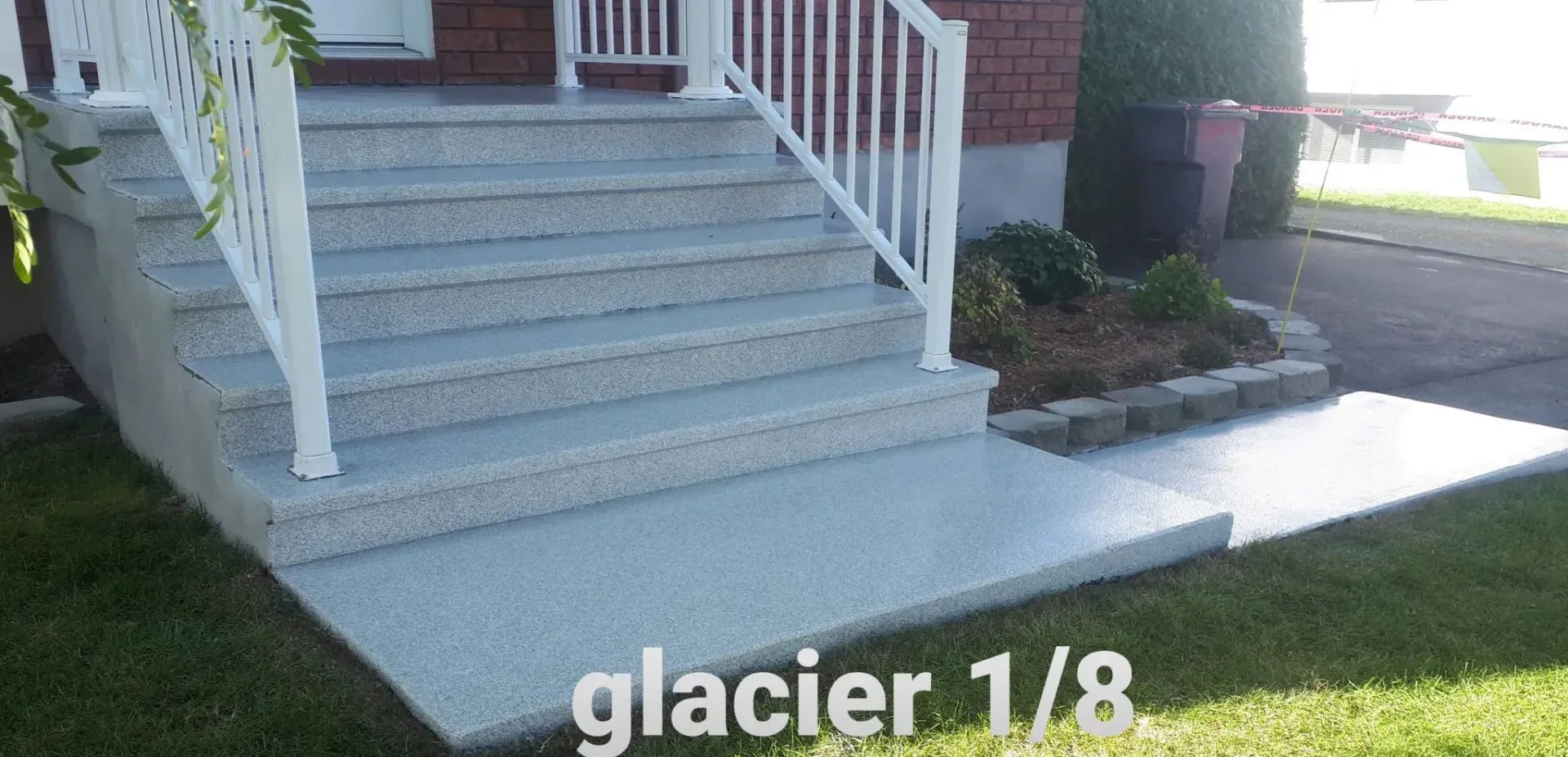Concrete stairs and walkway with white railing, and the text 