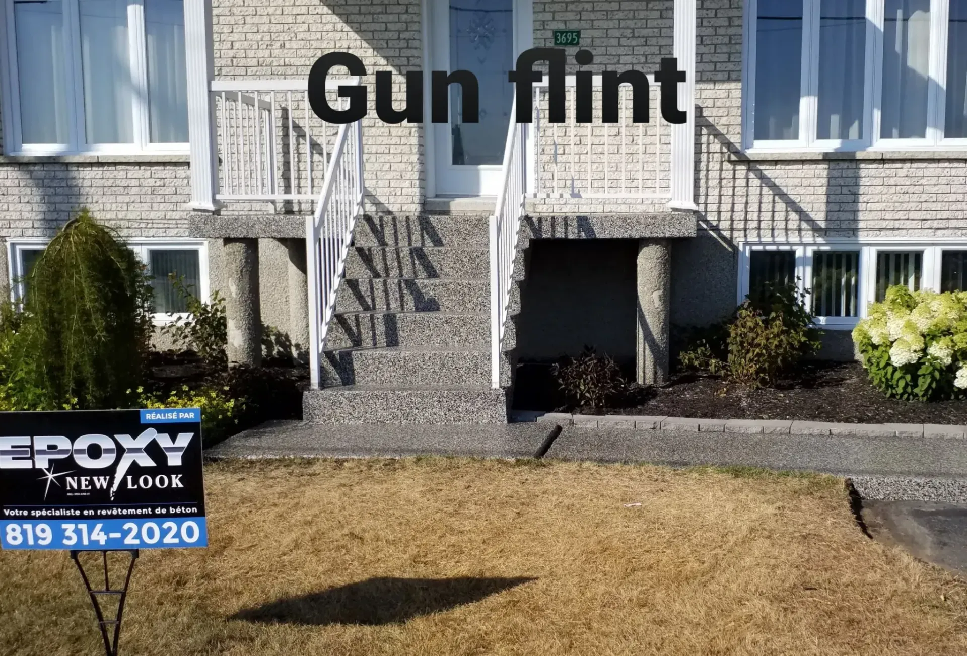 A house with stone facade, steps, and a sign for Epoxy Resurfacing.