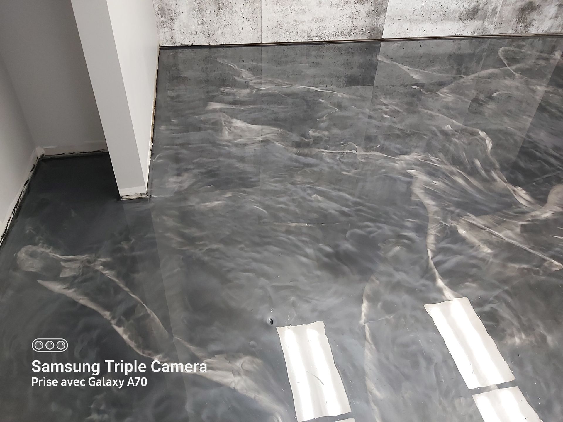 Metallic gray epoxy floor with swirling patterns in a room.