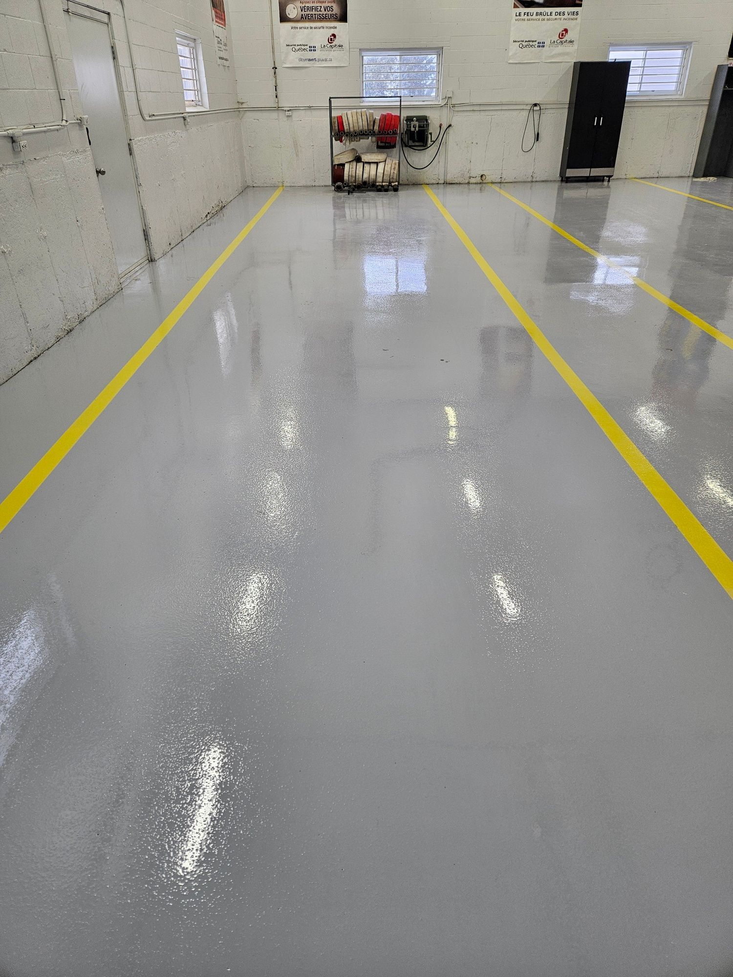 Gray industrial floor with yellow lines, equipment in background.