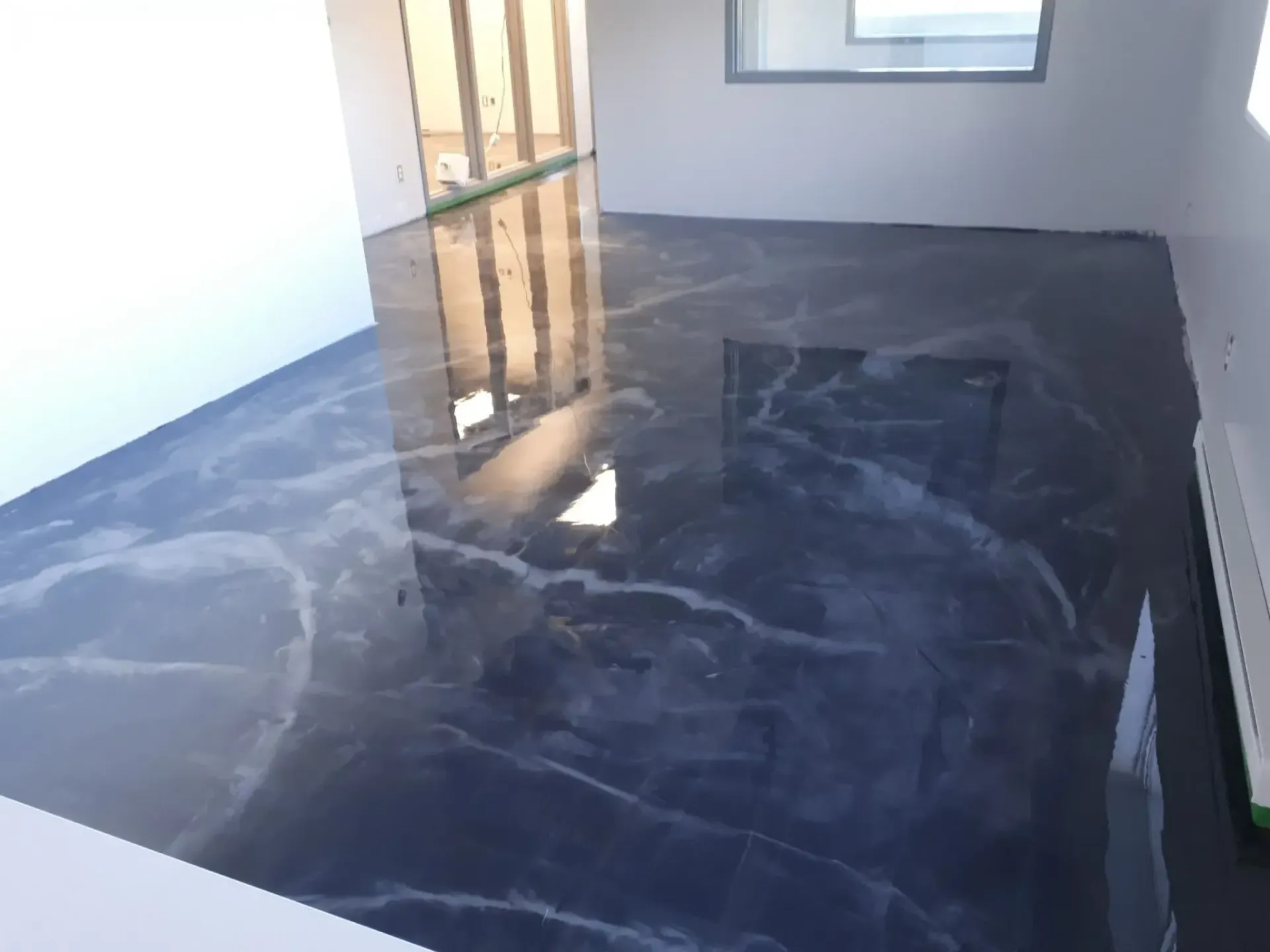 A room with a black marble floor and a window.