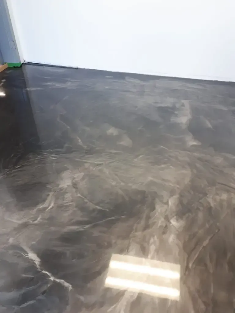 A close up of a black metallic floor in a room.