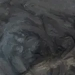 A close up of a painting of a face on a rock.