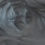 A close up of a person 's eye with a gray background.