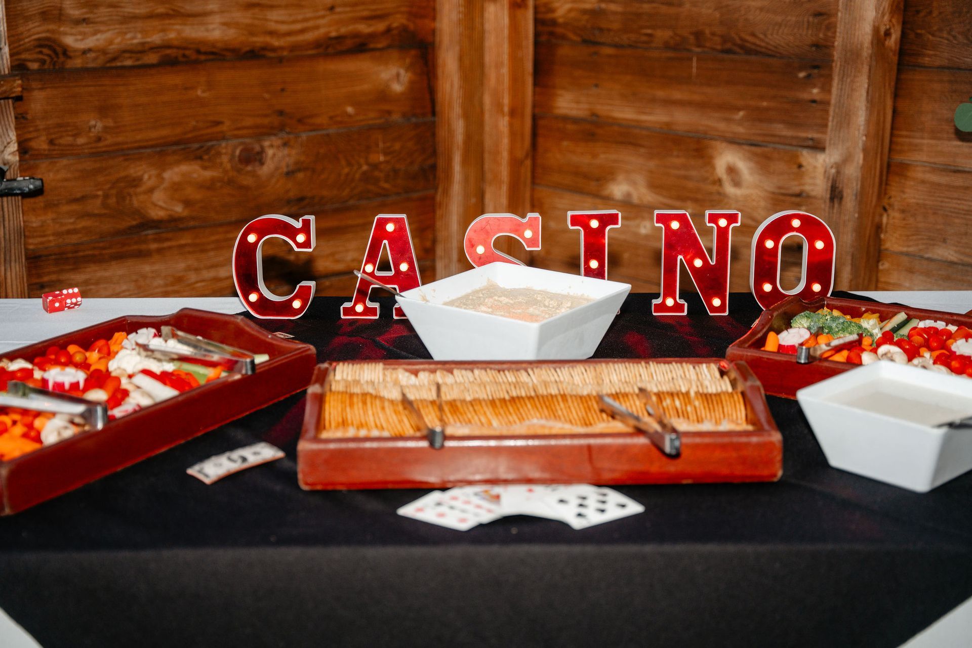Casino-themed food spread with wooden background, lit-up 