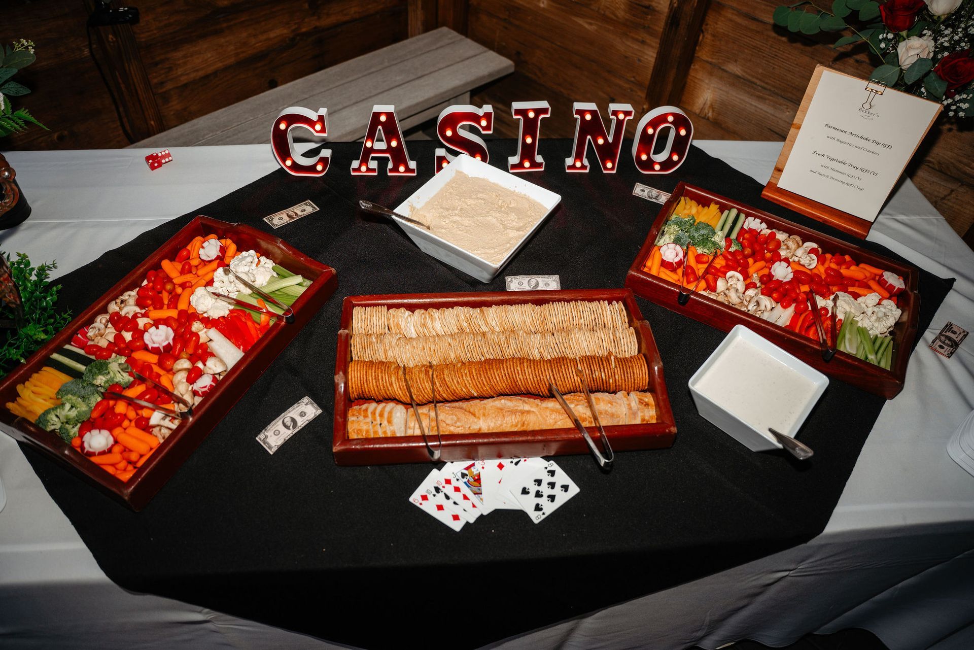Casino-themed food display: Vegetable trays, crackers, dips, and 