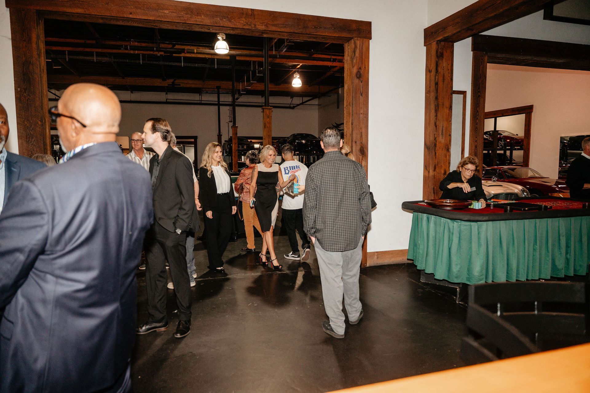 People at an event, some walking through a doorway to a casino table.