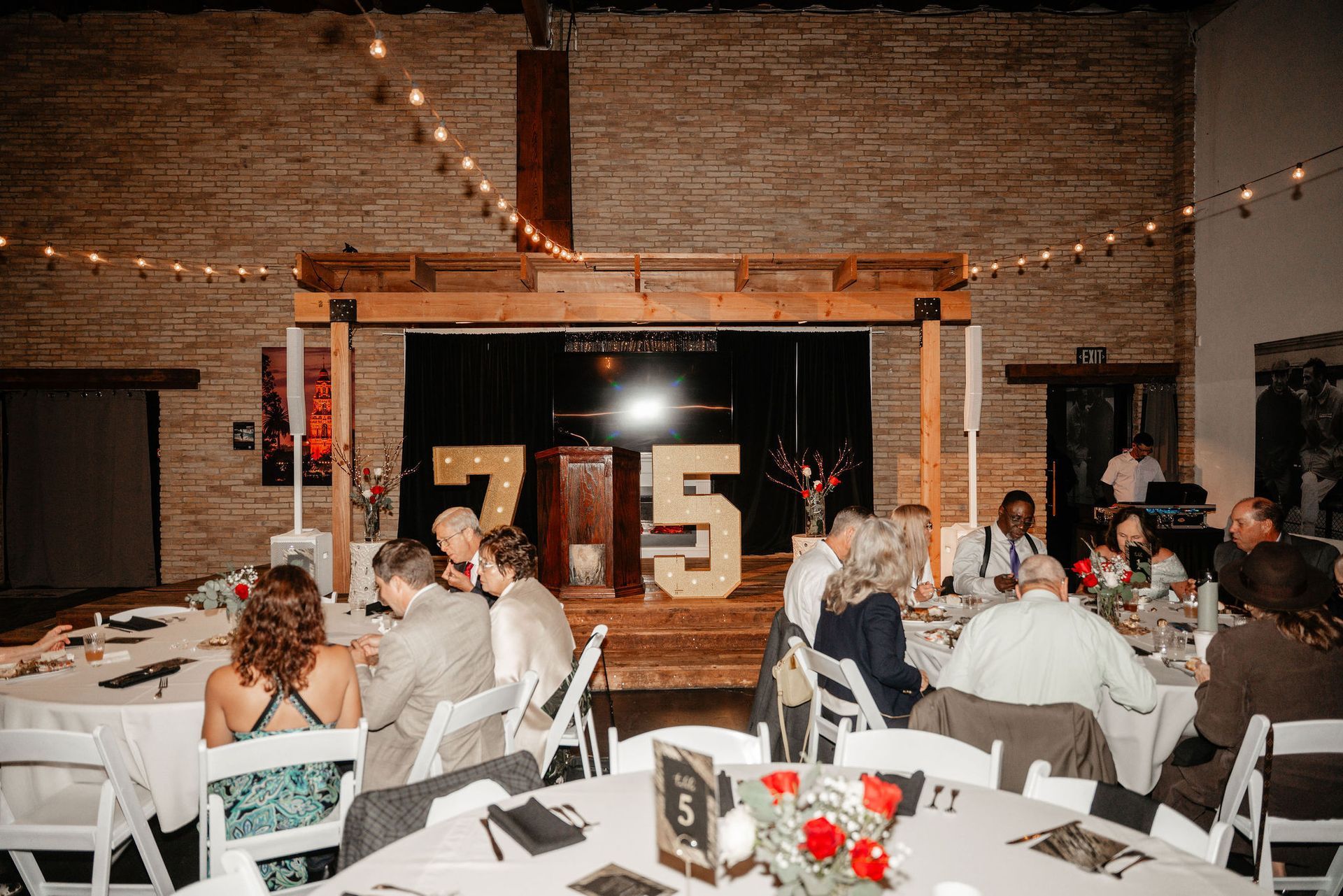 Reception with guests at tables, stage with large 