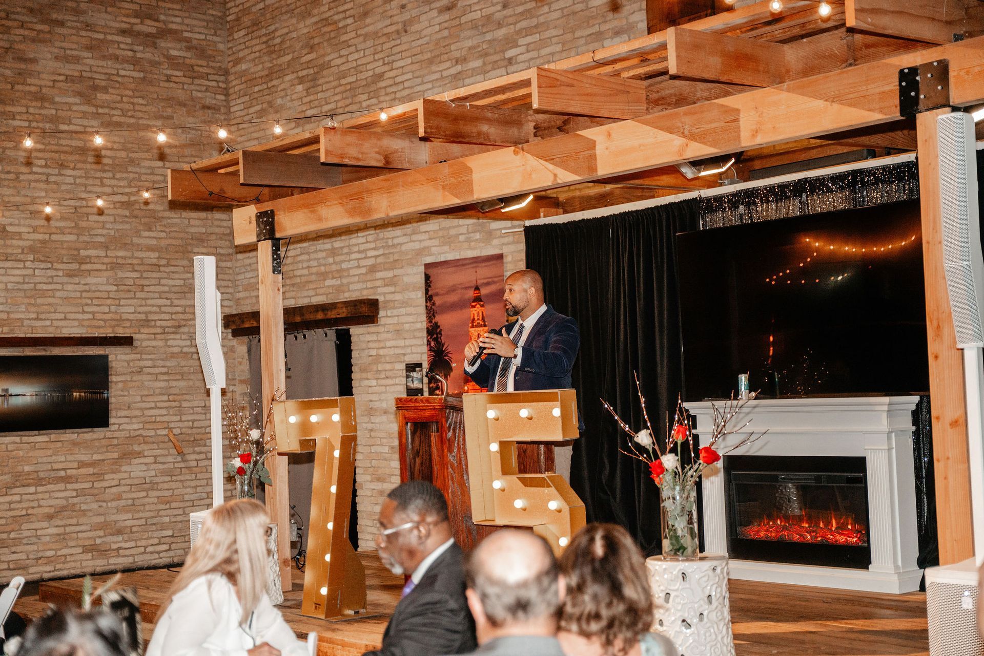 Man speaking at podium on stage with 