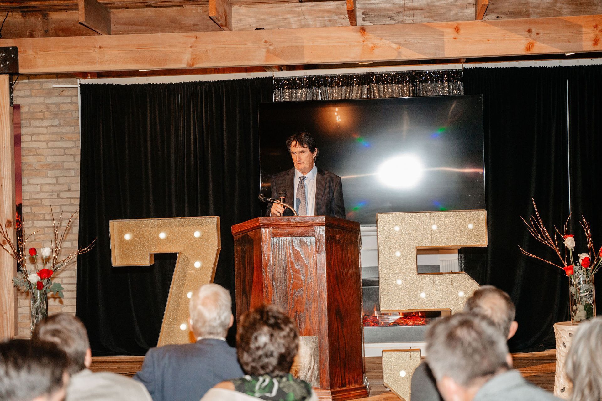 Man speaking at a podium, lit-up 