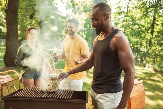 A group of people are having a barbecue in the park.