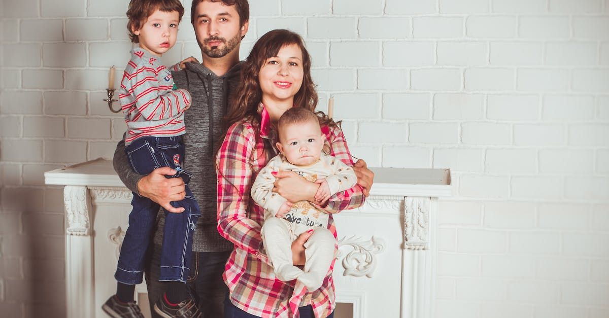 A family is posing for a picture in front of a fireplace.