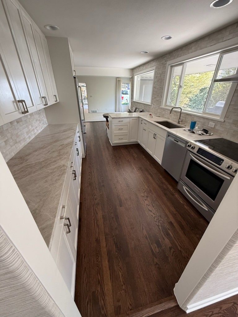 View of a wooden staircase with white risers and a small hallway featuring a framed black and white picture.