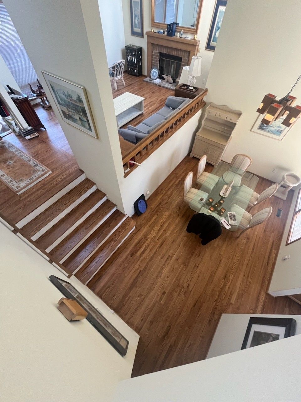 High-angle view of a living area featuring a fireplace, a sectional sofa, and a dining space.