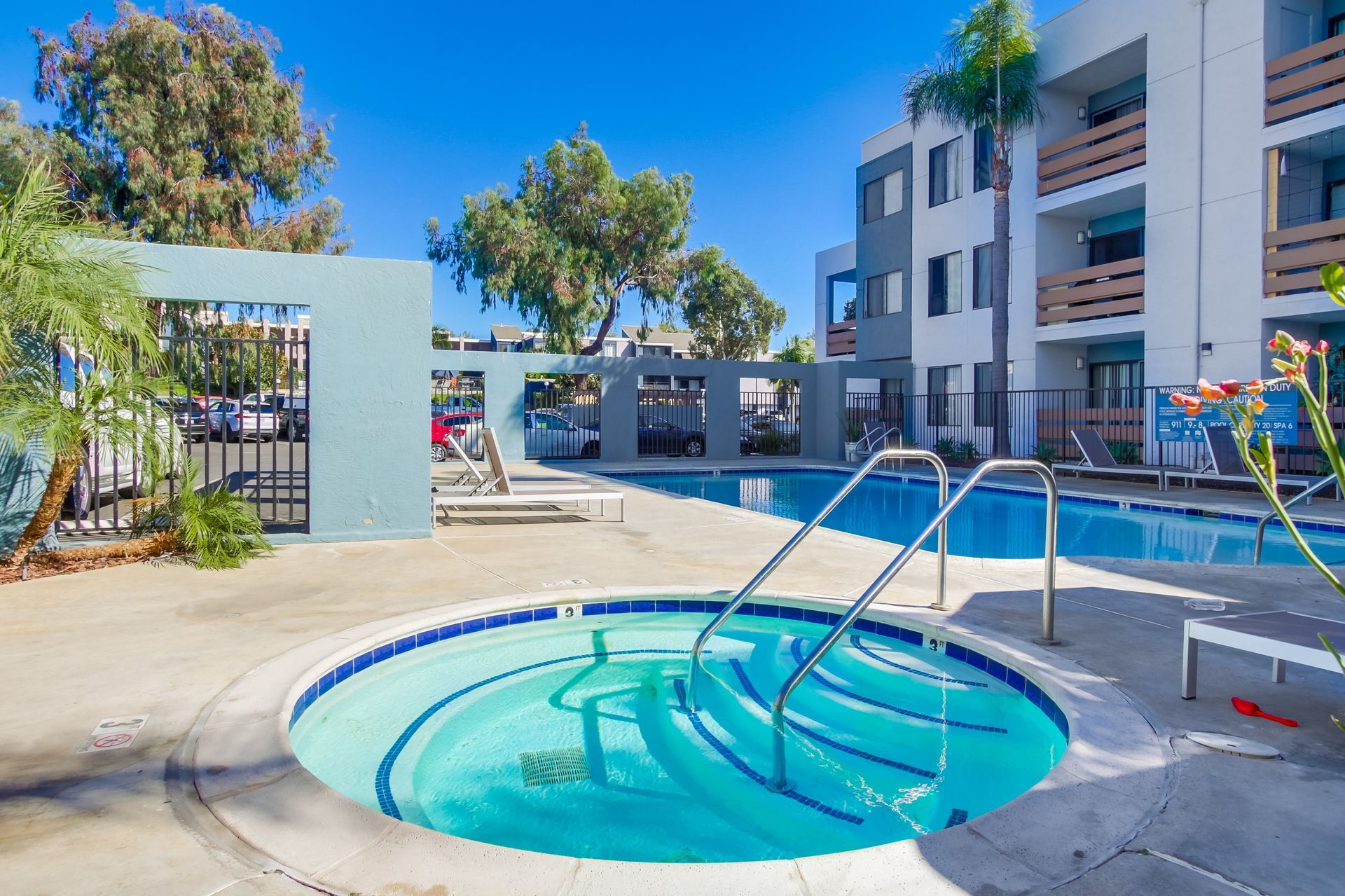 Hot tub and pool at apartment complex on a sunny day.