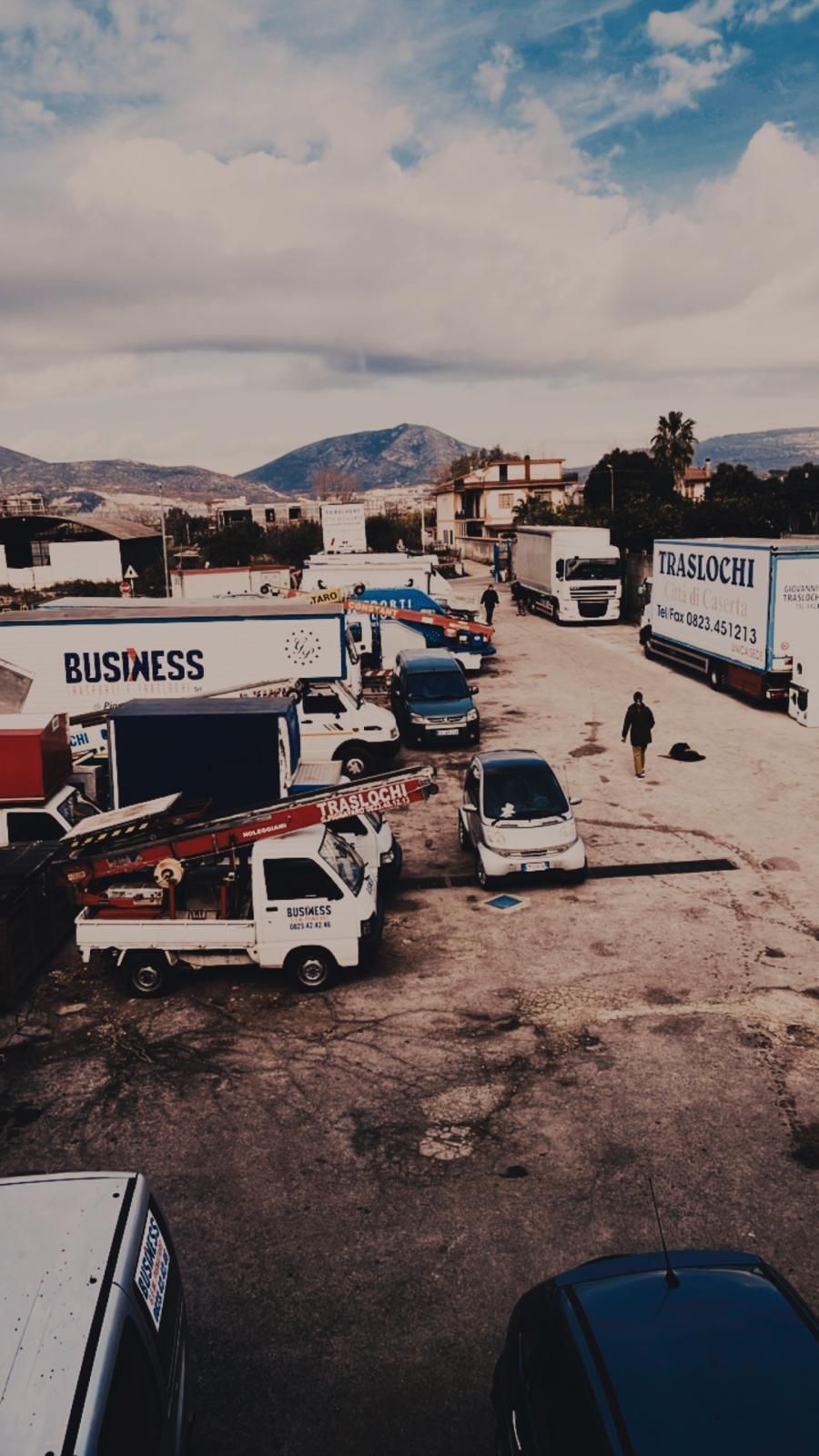 Un sacco di camion sono parcheggiati in un parcheggio e un camion ha la parola business su di esso