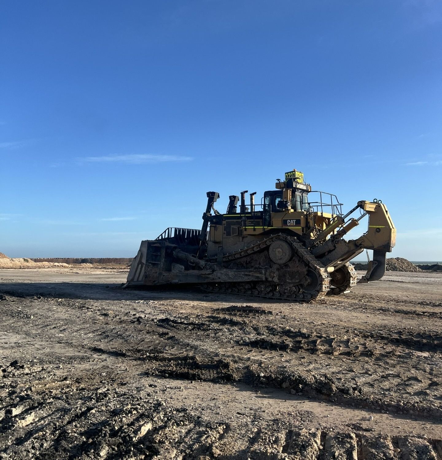 Yellow Bulldozer Working on a Construction Site Under a Blue Sky — Waite Diesel Service in Douglas, QLD