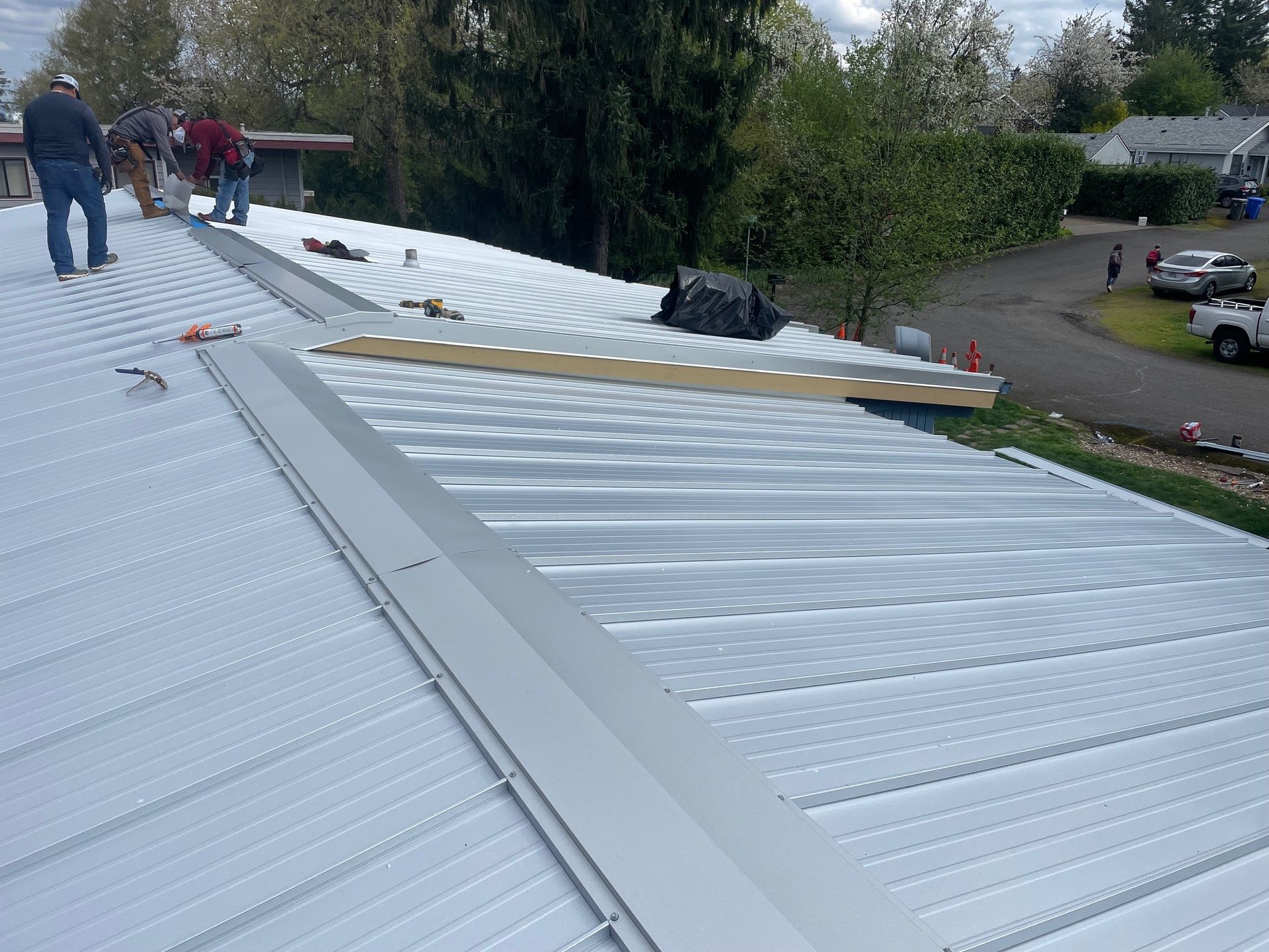 Workers installing a metal roof on a residential building.