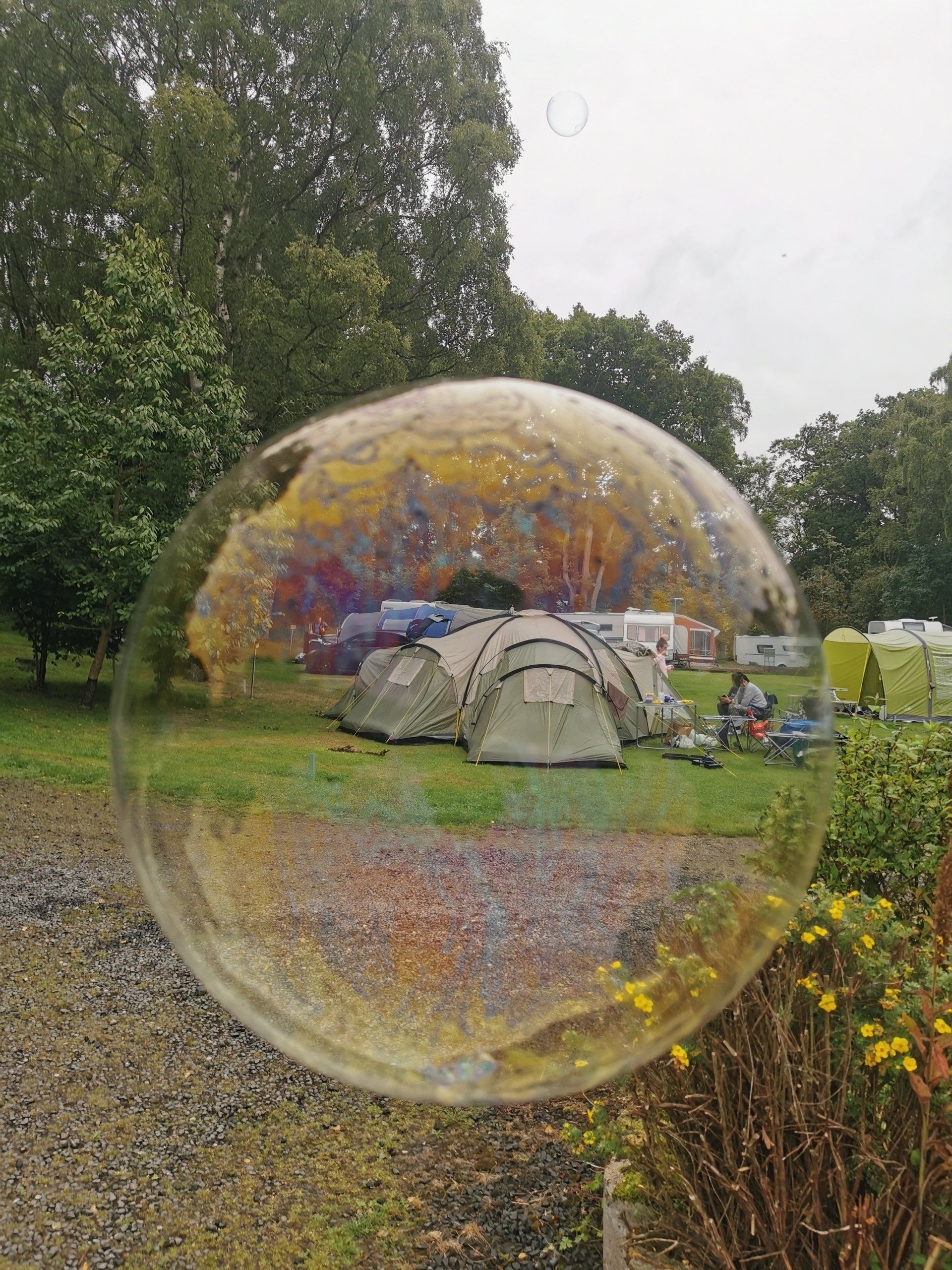 Image of a tent viewed through the lens of a soap bubble