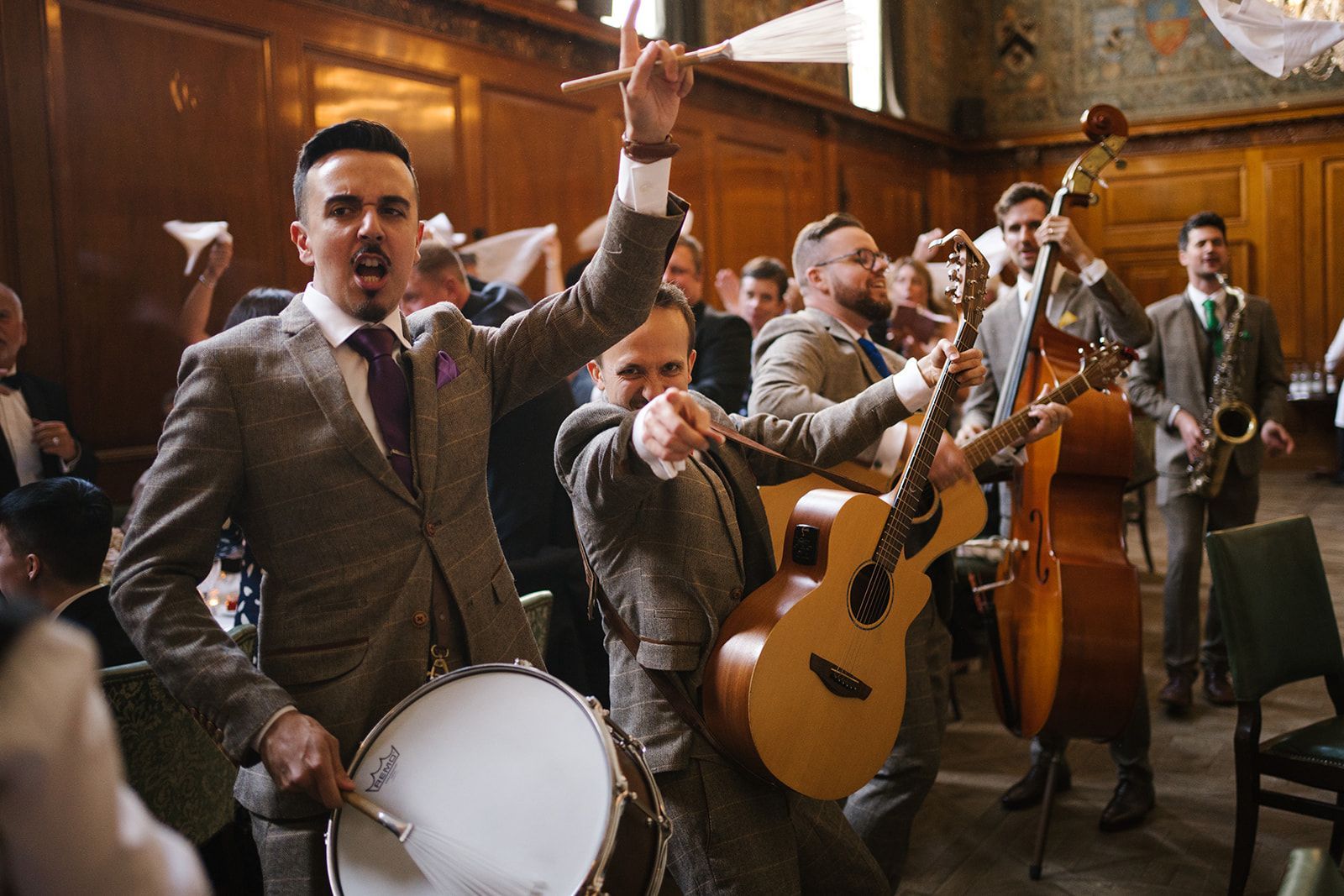 A group of men in suits are playing instruments in a room.