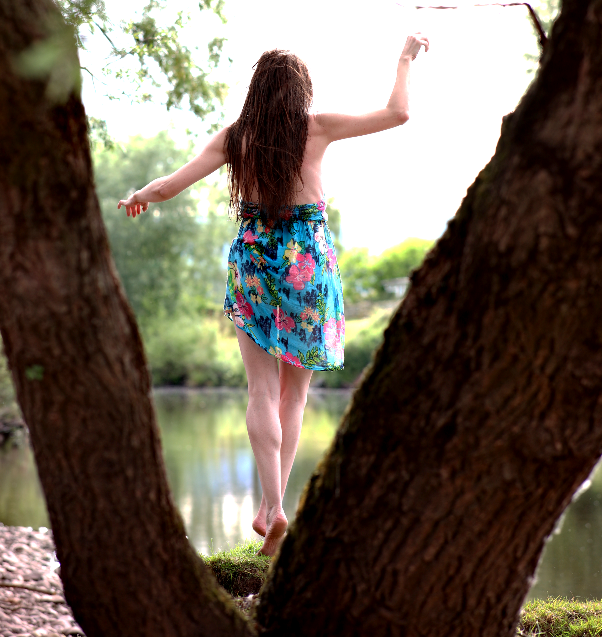 A woman in a short summer dress on a river bank.