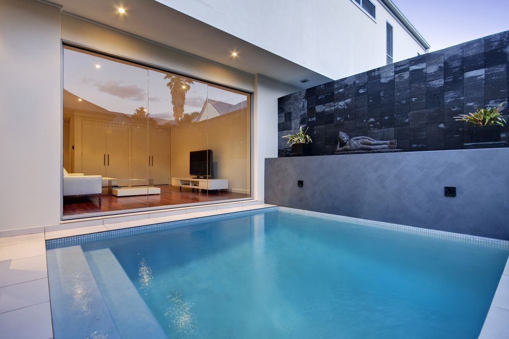 Small Outdoor Pool With Clear Glass Sliding Door to a Modern Living Room — East Coast Pool Resurfacing In Coffs Harbour, NSW