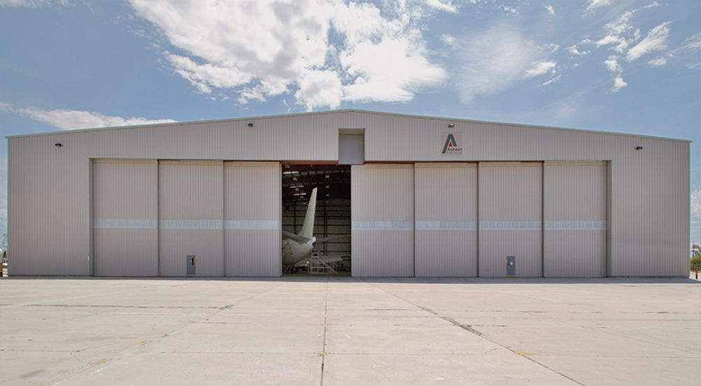 A large hangar with a plane inside of it