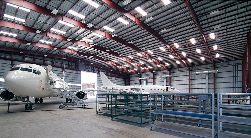 An airplane is parked inside of a large hangar