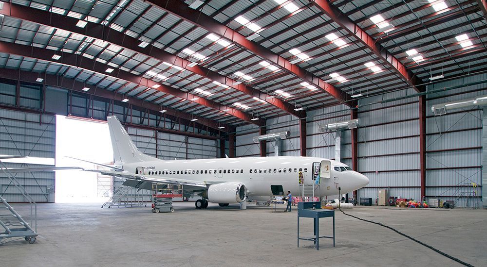 An airplane is parked inside of a large hangar