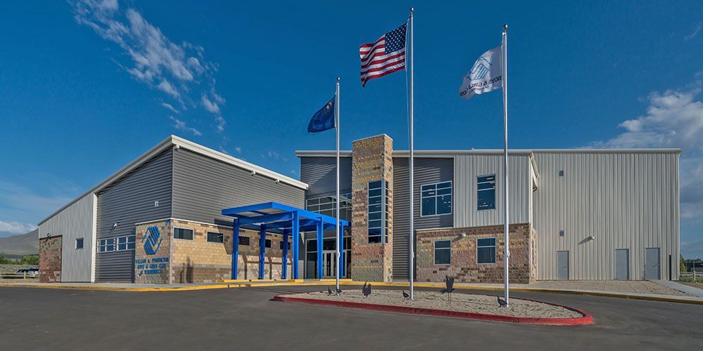 A large building with three flags flying in front of it.