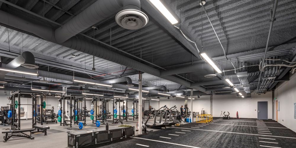 A large gym filled with lots of exercise equipment and a treadmill.